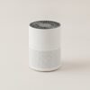 Purificateur d'air compact cylindrique blanc avec grille d'aspiration, vue de face