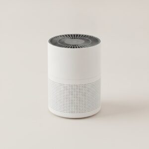 Purificateur d'air compact cylindrique blanc avec grille d'aspiration, vue de face