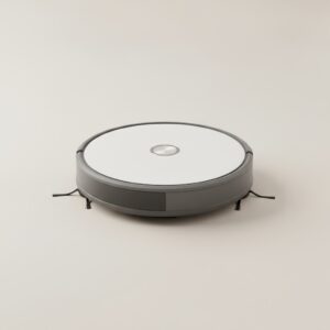 Robot aspirateur compact rond vu de trois quarts sur fond gris clair