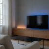 Ruban lumineux installé derrière un meuble télé dans un séjour au crépuscule