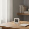 Station de mesure d'air posée sur un bureau en bois clair près d'une fenêtre