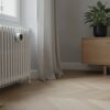 Tête thermostatique installée sur un radiateur blanc dans un salon lumineux